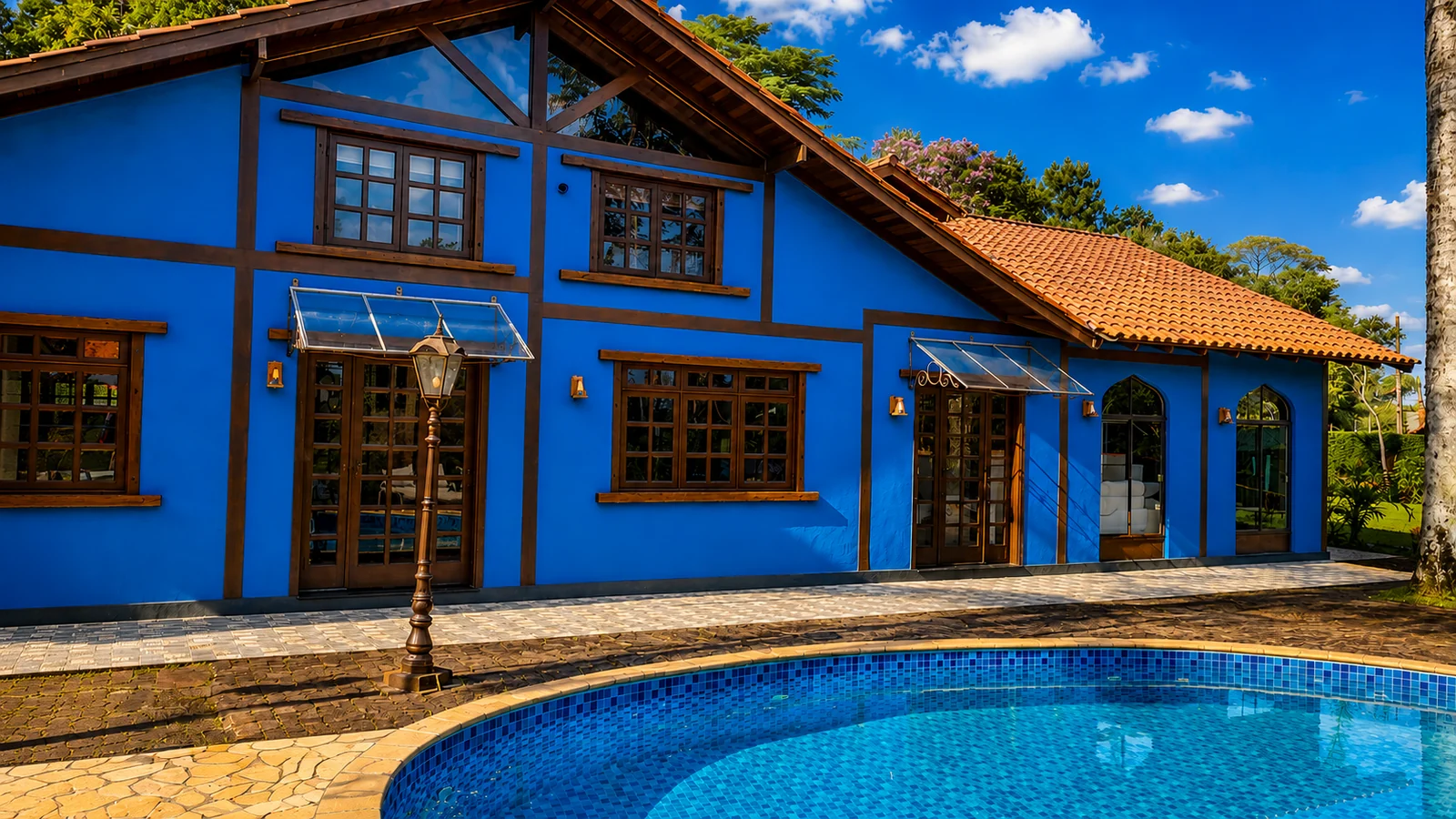 Fachada azul da Casa da Represa ao lado da piscina